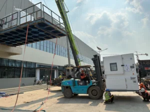รถยกขนย้ายเครื่องจักรหนักขึ้นวางบนรถเทรลเลอร์พื้นเรียบ